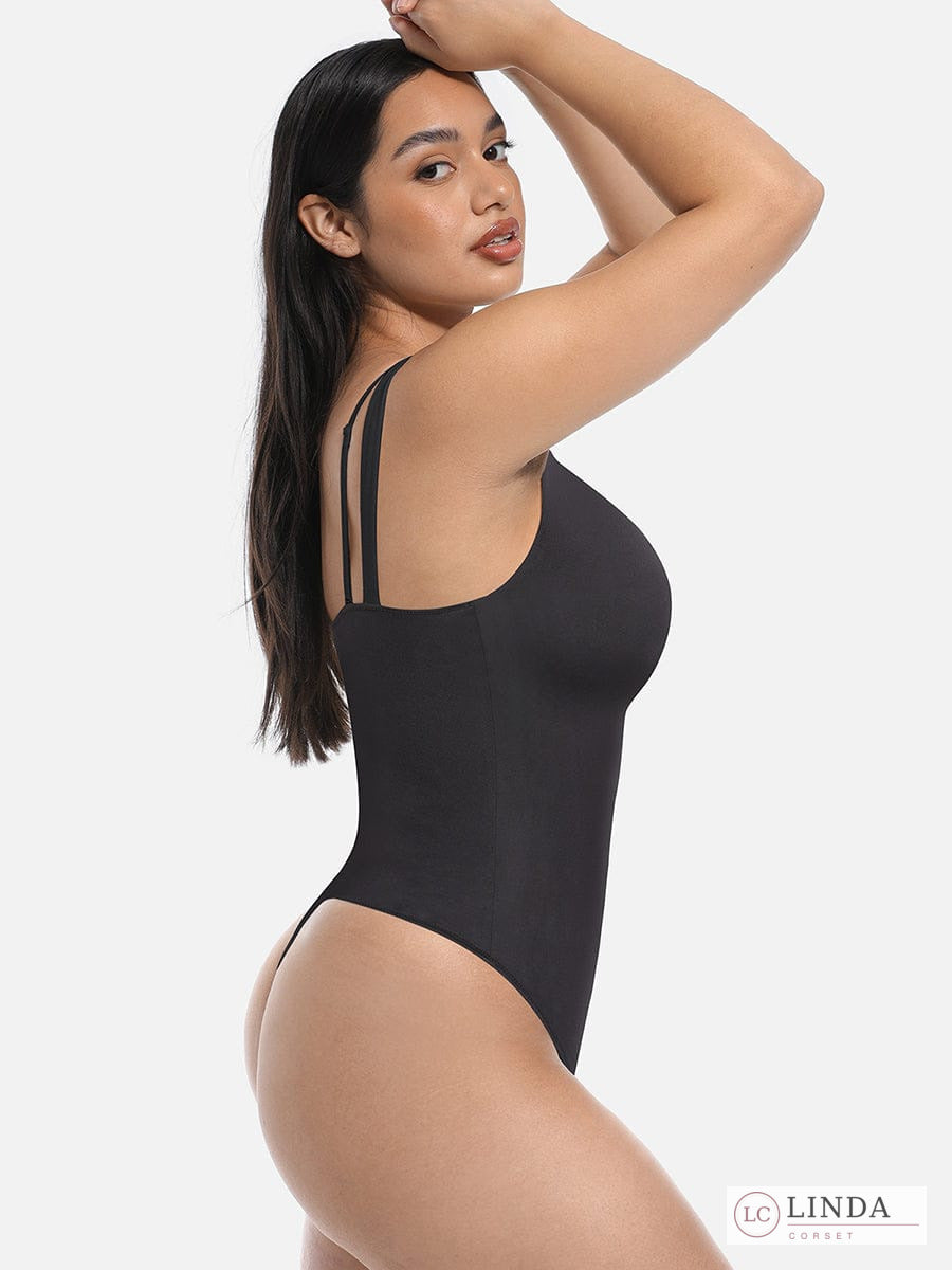 Woman wearing a black bodysuit with thin straps on a white background